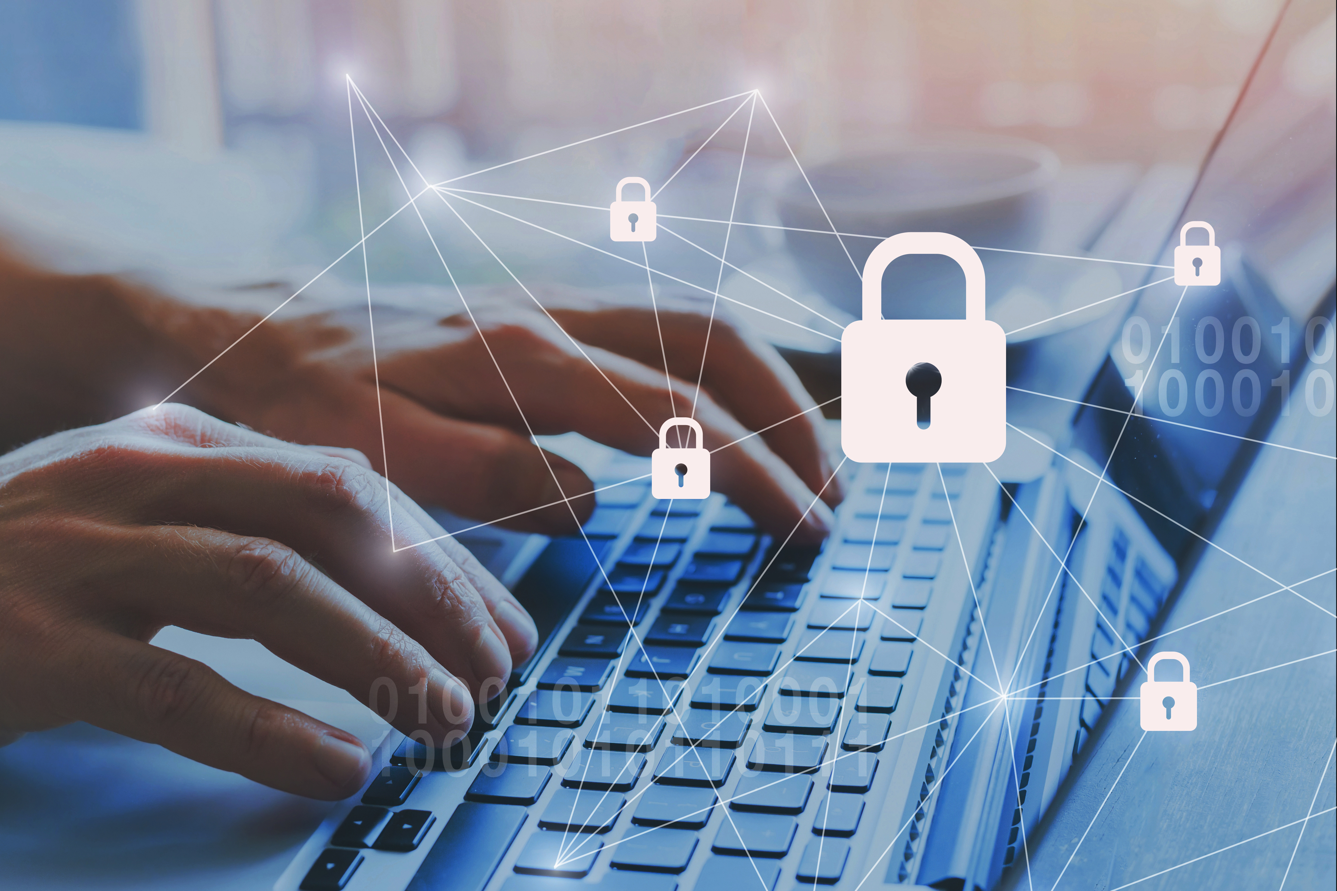 [hands typing on a laptop with security symbols}